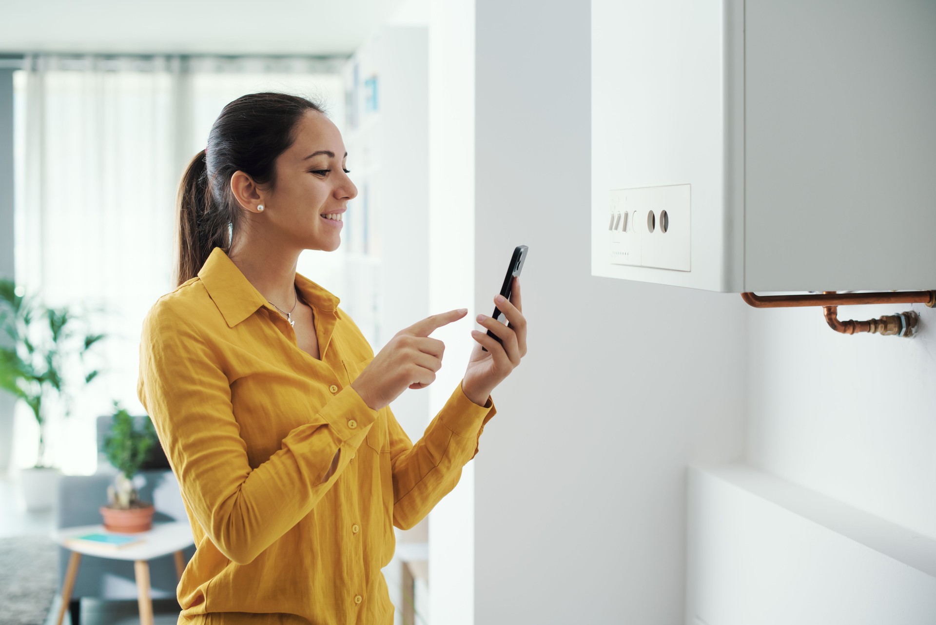 Woman managing her smart boiler using her phone